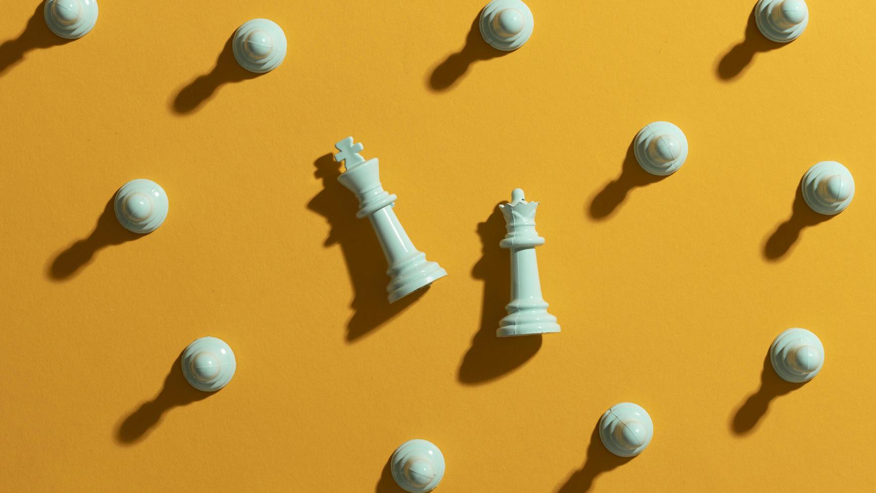 White chess pieces on yellow background photo