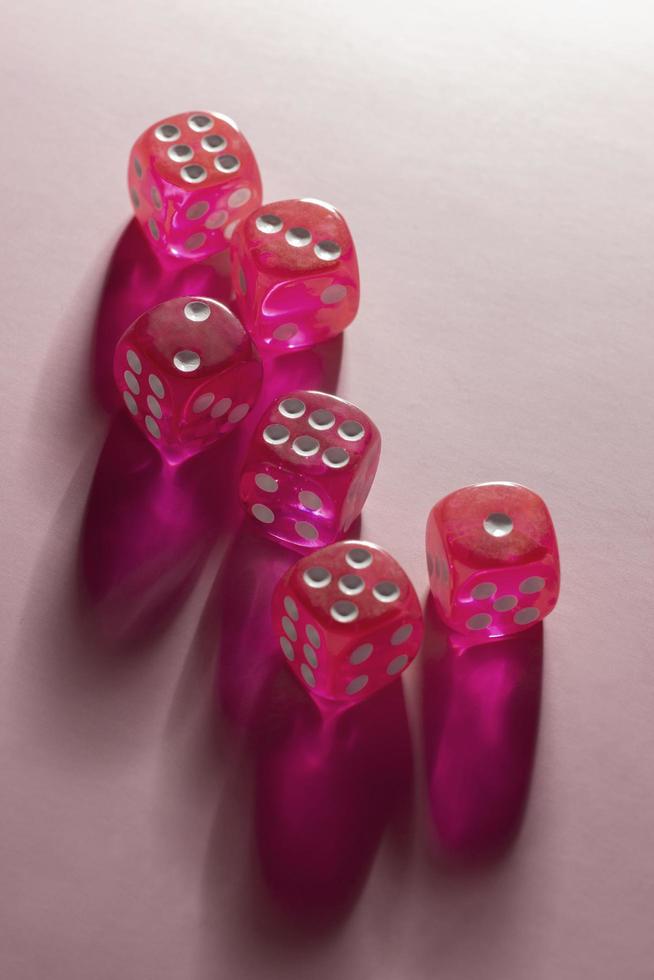Pink dice on pink background photo