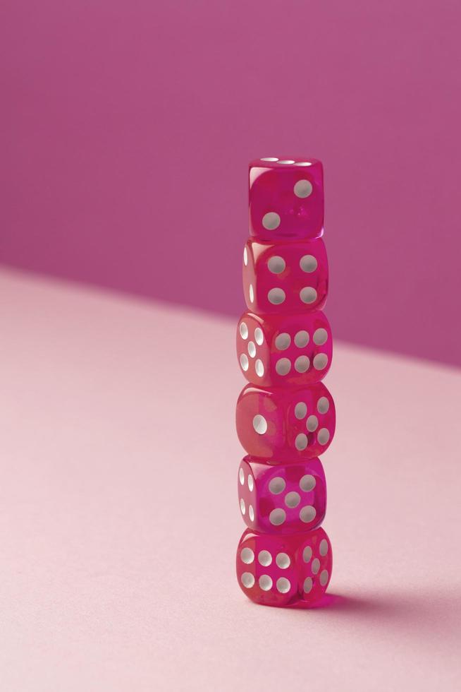 Stacked pink dice on pink background photo