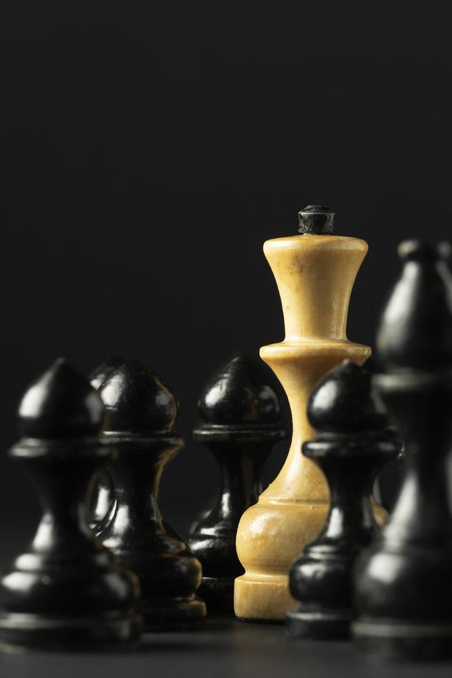 Black and white chess pieces on black background photo