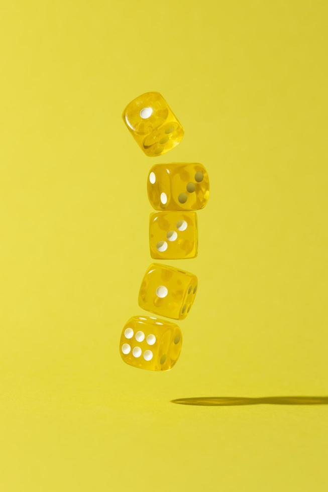 Falling yellow dice on yellow background photo