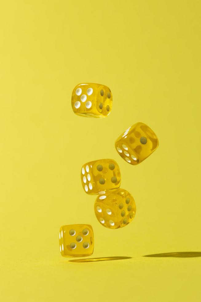 Falling yellow dice on yellow background photo