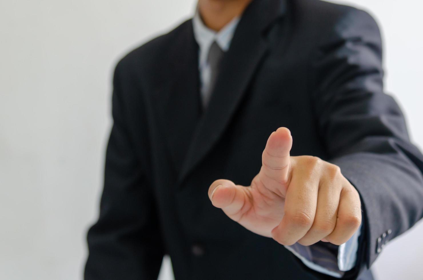 Businessman wearing a suit pointing fingers in front. photo