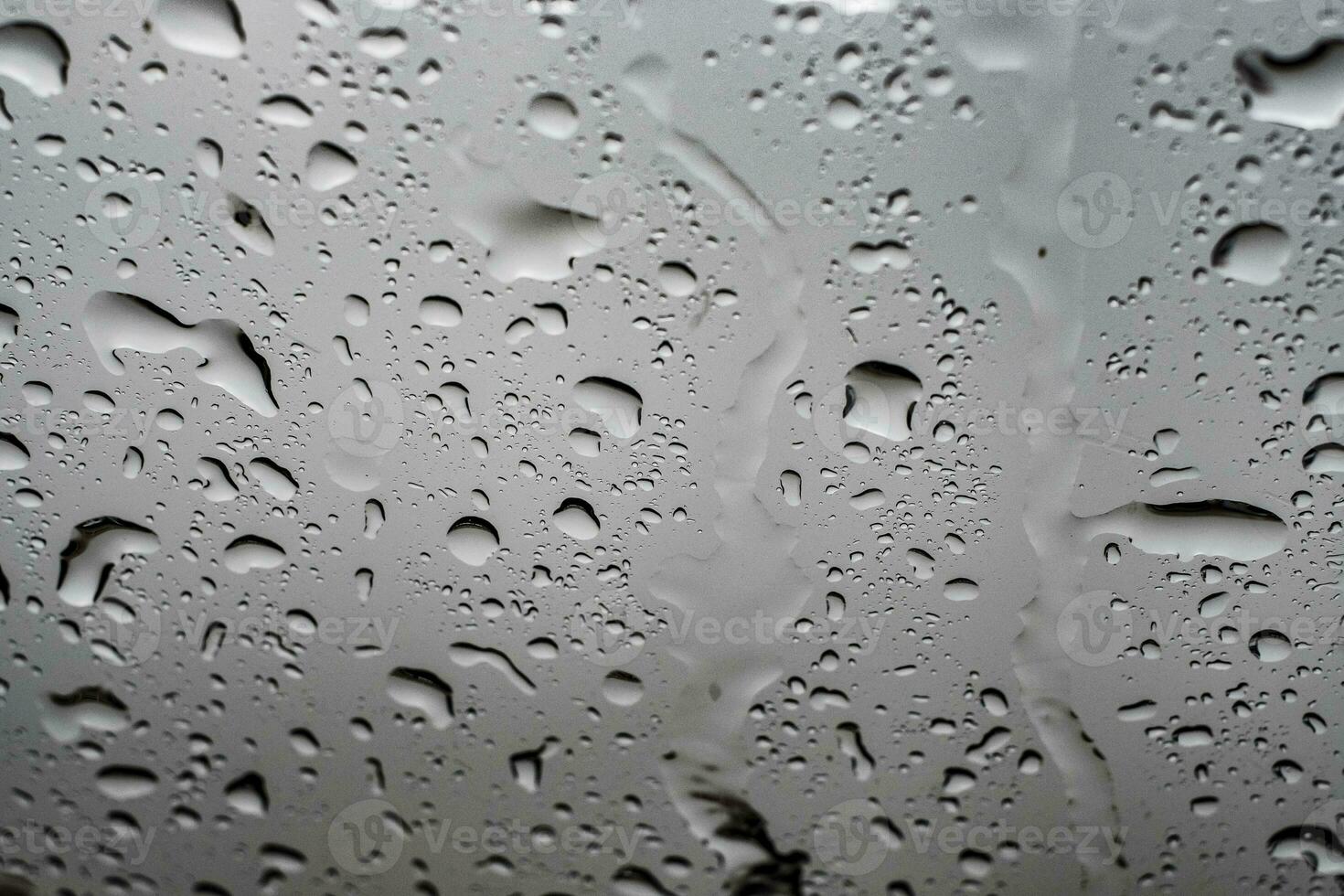 Gotas de lluvia de agua sobre el cristal de la ventana de un coche foto