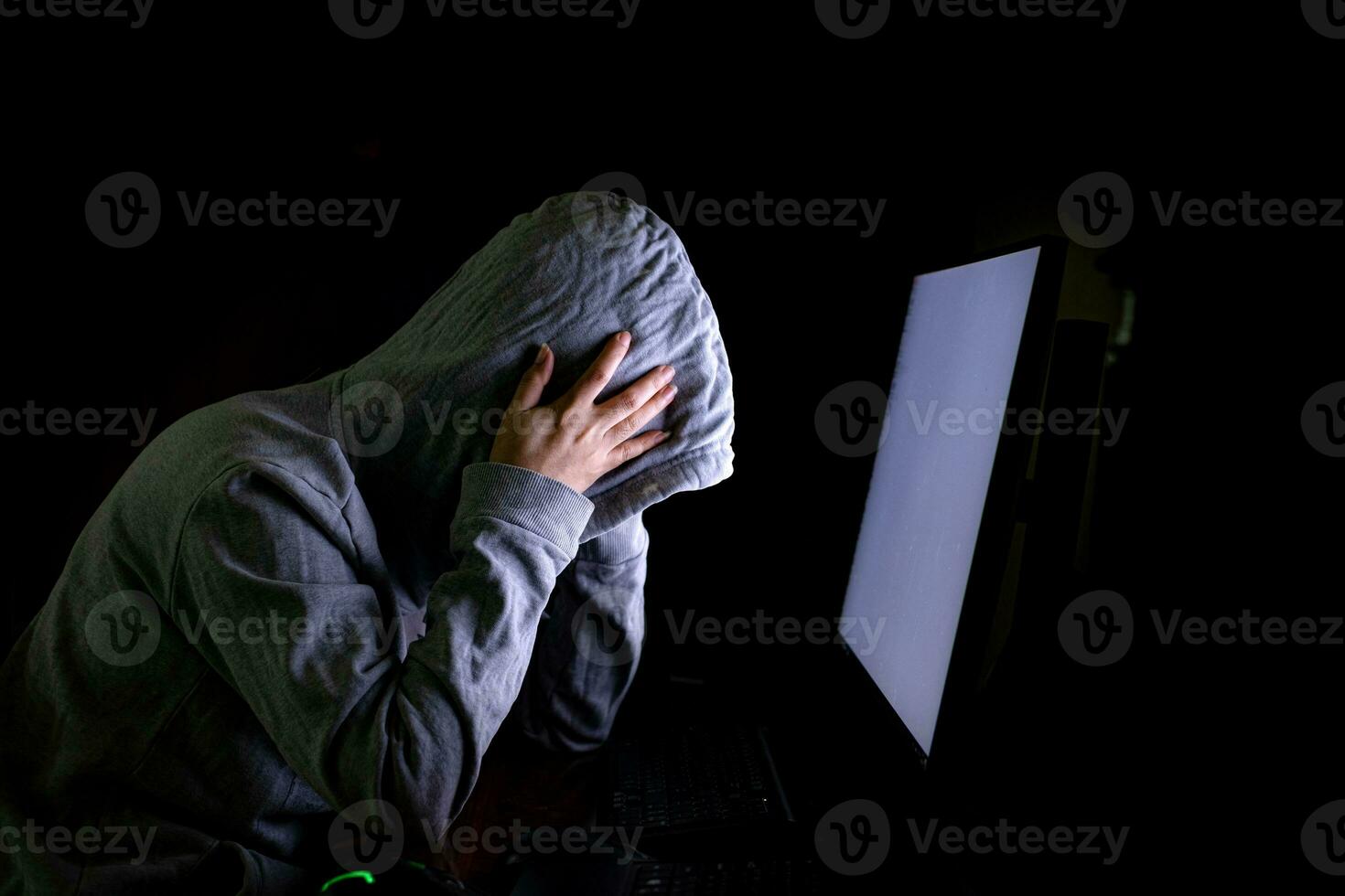Women hacker breaks into government data servers and infects their system with a virus at his hideout place, dark blue atmosphere, hooded lady using laptop with binary code background, malware concept photo