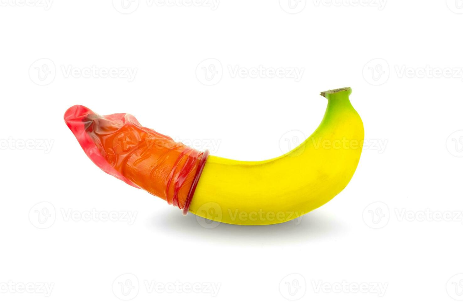 Red condom worn on a banana on a white background photo