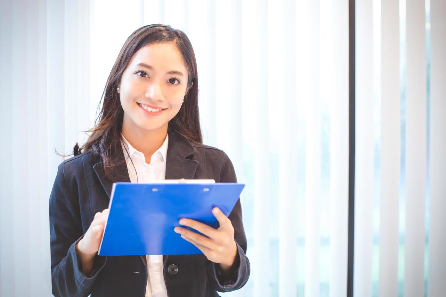 Woman smiling and holding clip board photo