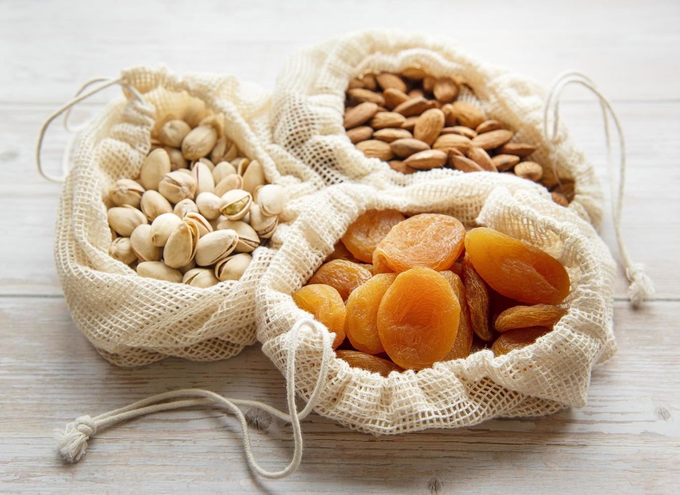 Eco bags with pistachios almonds and dried apricots photo