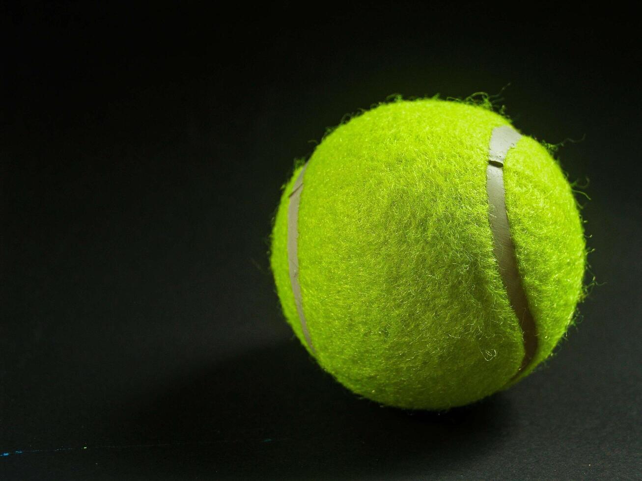 Tennis ball on black background photo