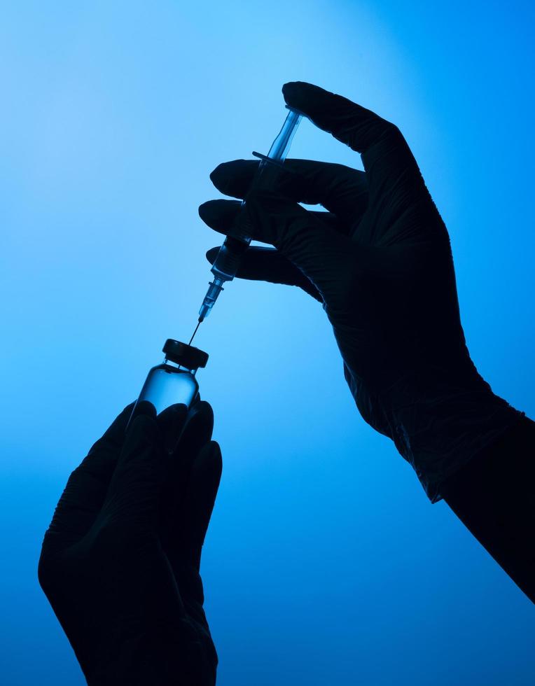 Hands with protective gloves holding a covid vaccine photo