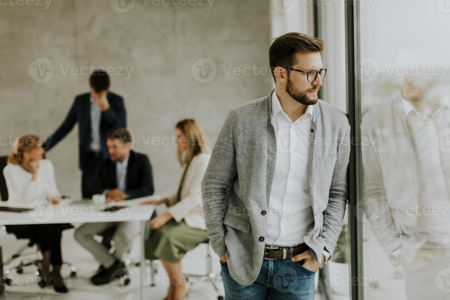 Man talking a break and looking out a window in an office photo