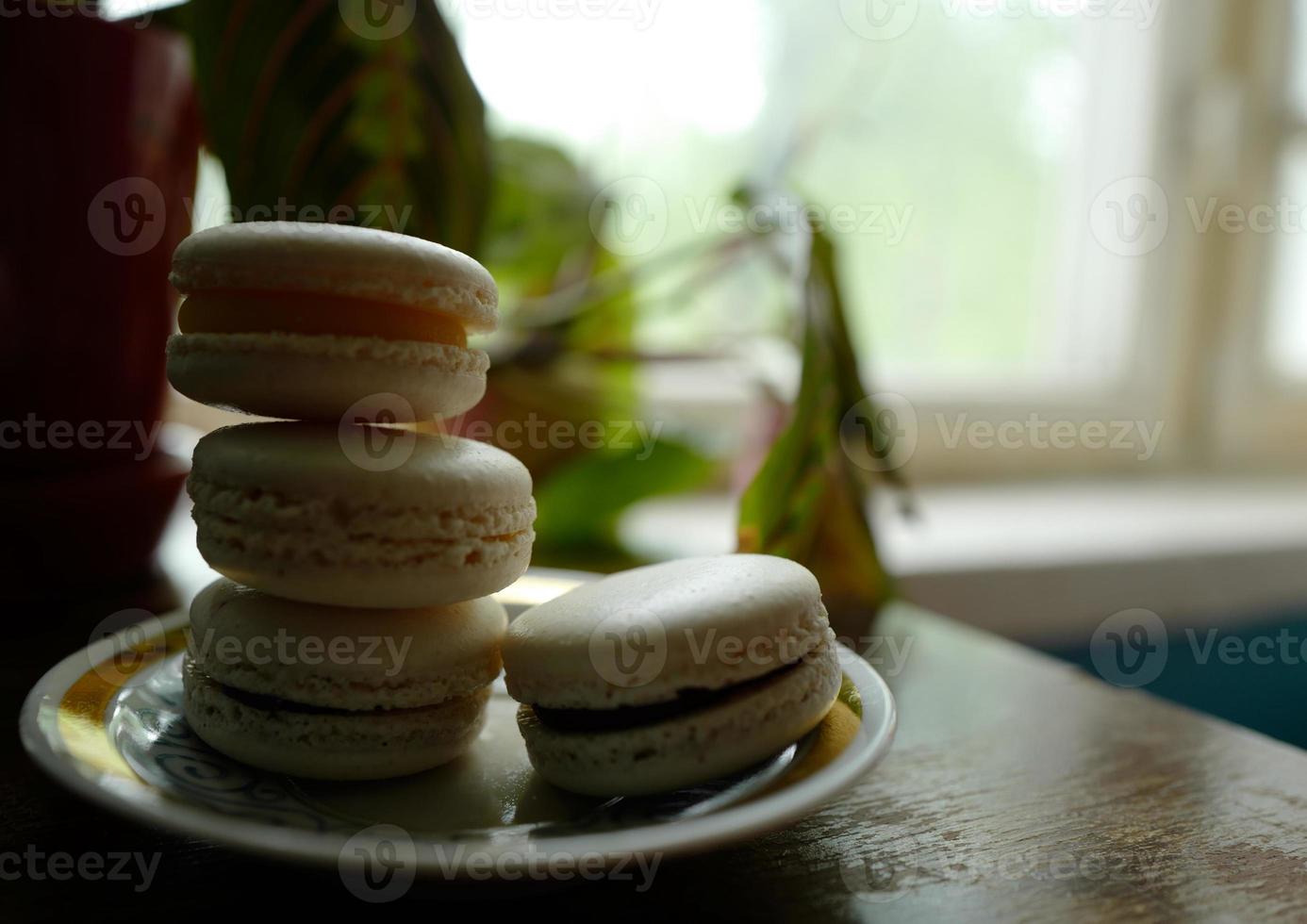 Four macaron desserts on a saucer photo