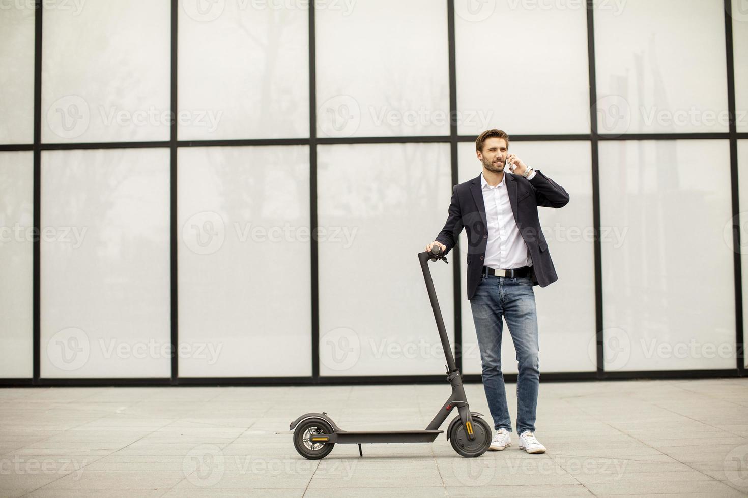 hombre con scooter hablando por teléfono foto