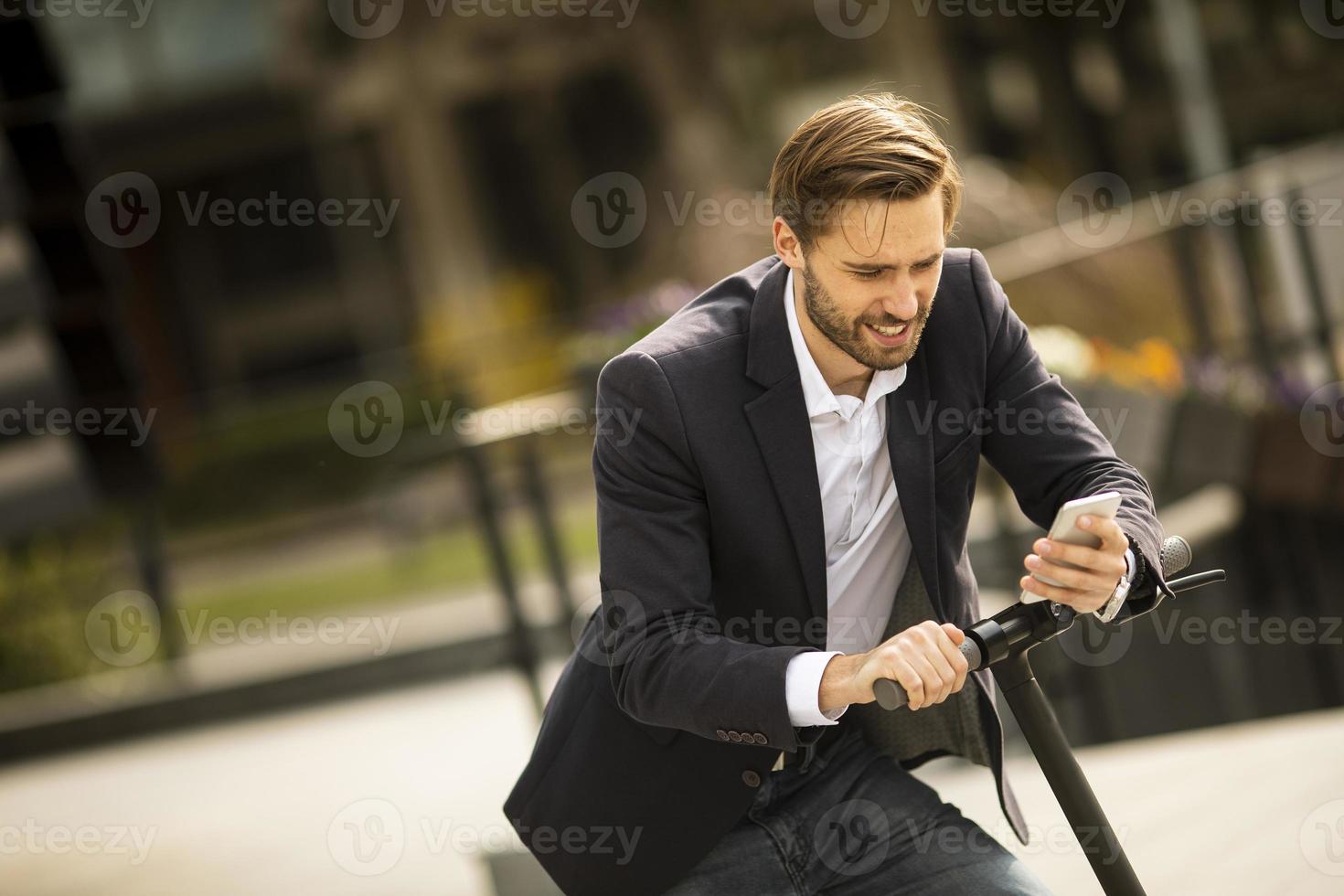 hombre montando scooter mientras habla por teléfono foto