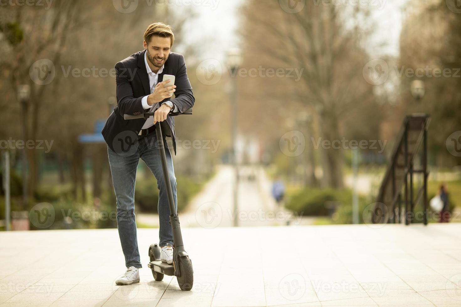 hombre en scooter y mensajes de texto en un teléfono foto