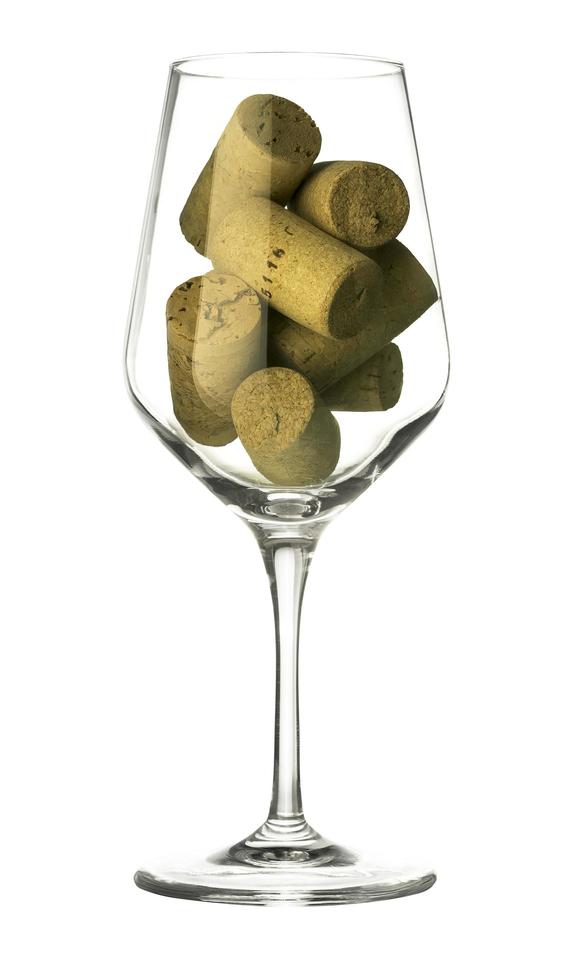 Wine glass and corks on white photo
