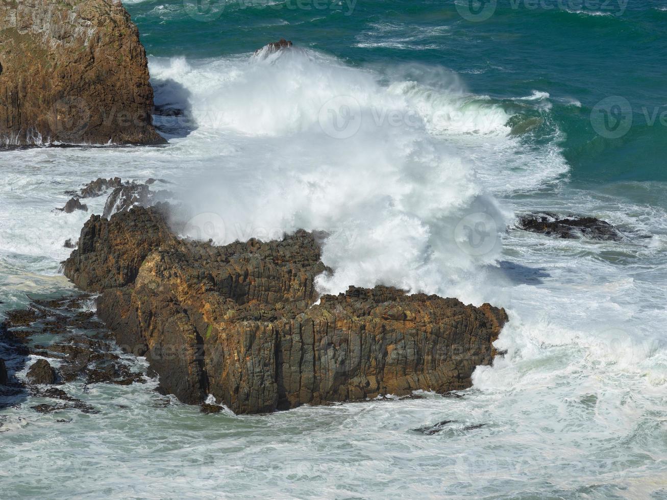 oleaje estrellándose sobre rocas en el punto de pepita foto