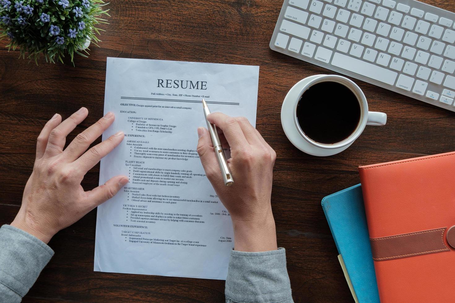 New graduate student holding resume application with pen coffee cup keyboard and notebook for applying for a job. photo