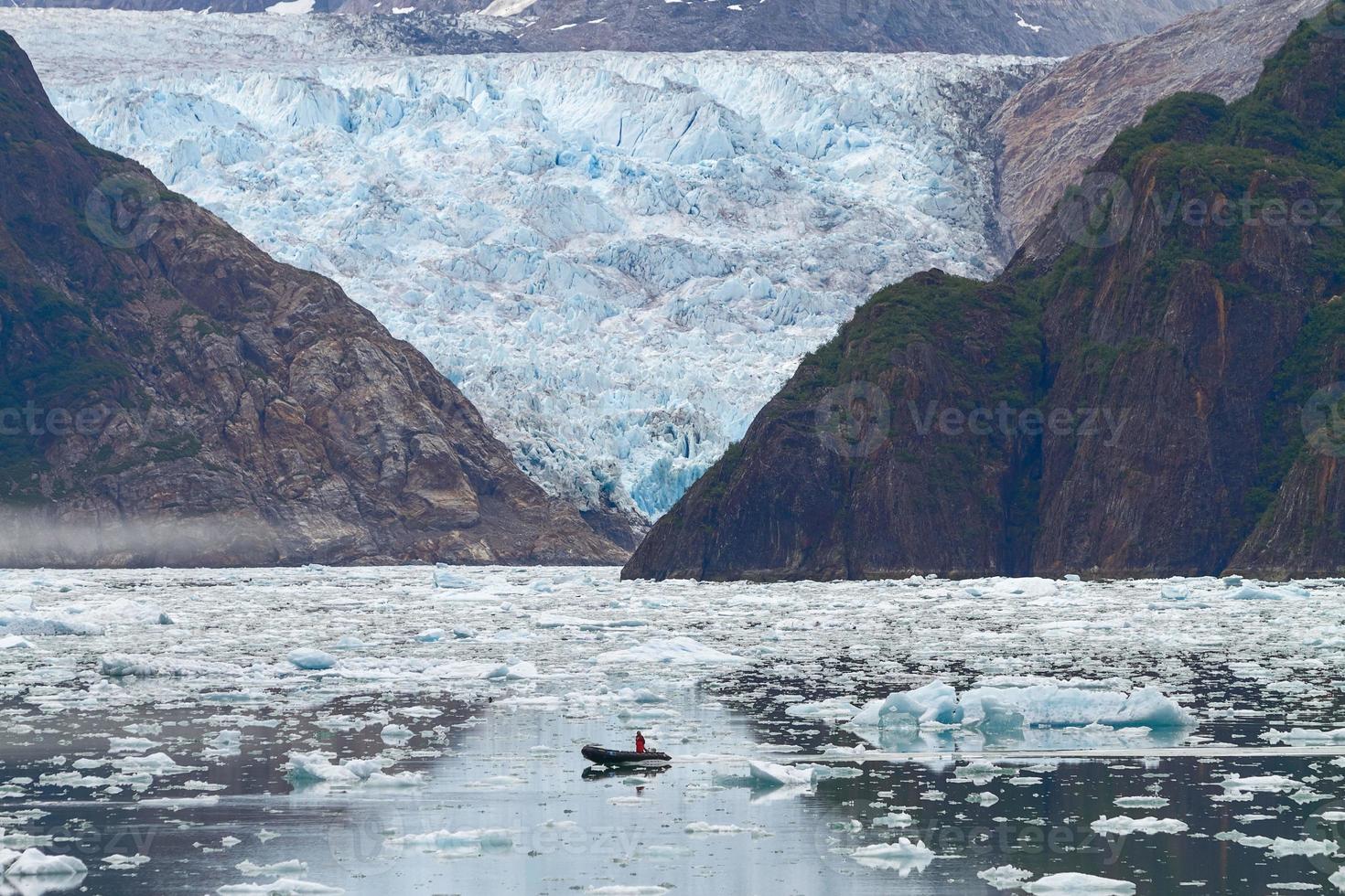 Hombre en barco delante del glaciar Sawyer en los fiordos de Tracy Arms en Alaska, Estados Unidos foto