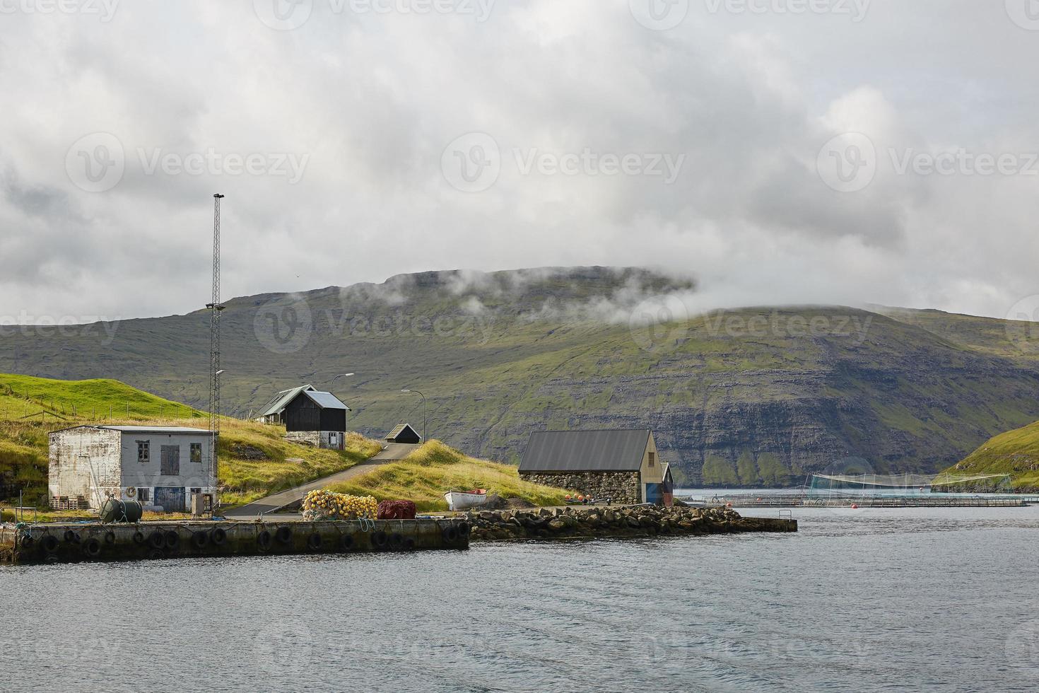 Village in wild and beautiful coastal landscape of Faroe Islands Denmark photo