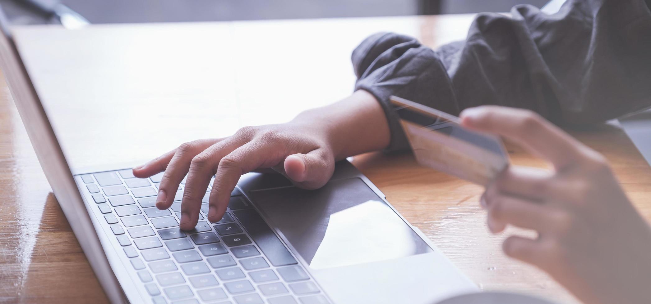 las compras en línea. Mujer asiática escribiendo información de la tarjeta de crédito con el teclado de la computadora portátil para comprar en línea. foto