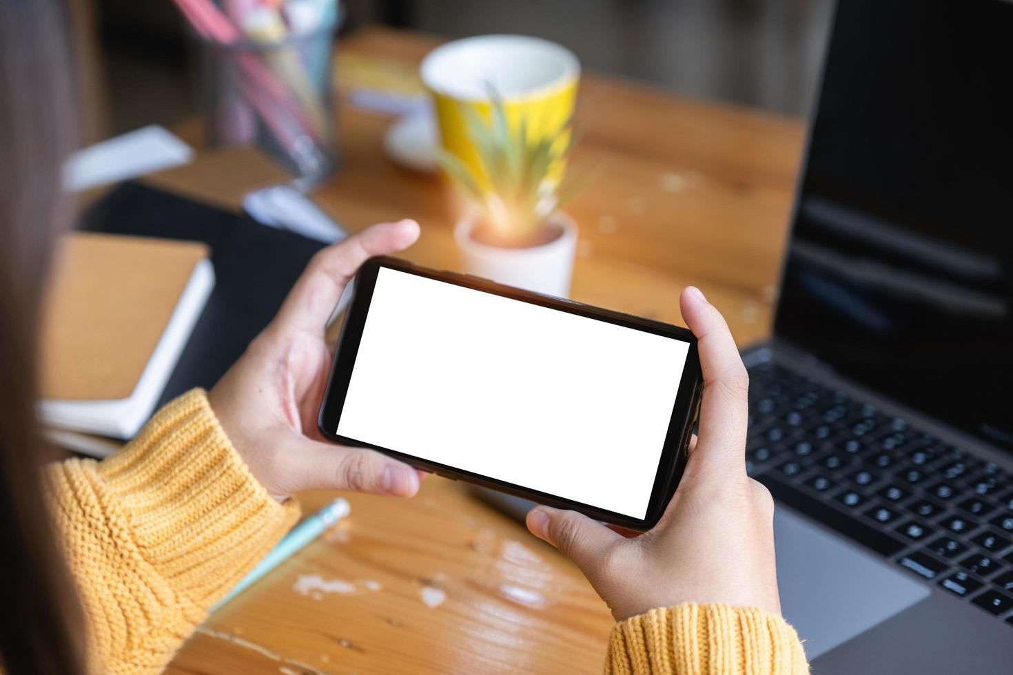 Close up of woman's hands using a mock-up smartphone with blank screen. photo