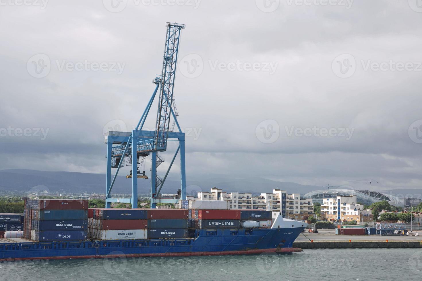 Grandes grúas industriales cargando un buque portacontenedores en el puerto de Dublín en Irlanda foto