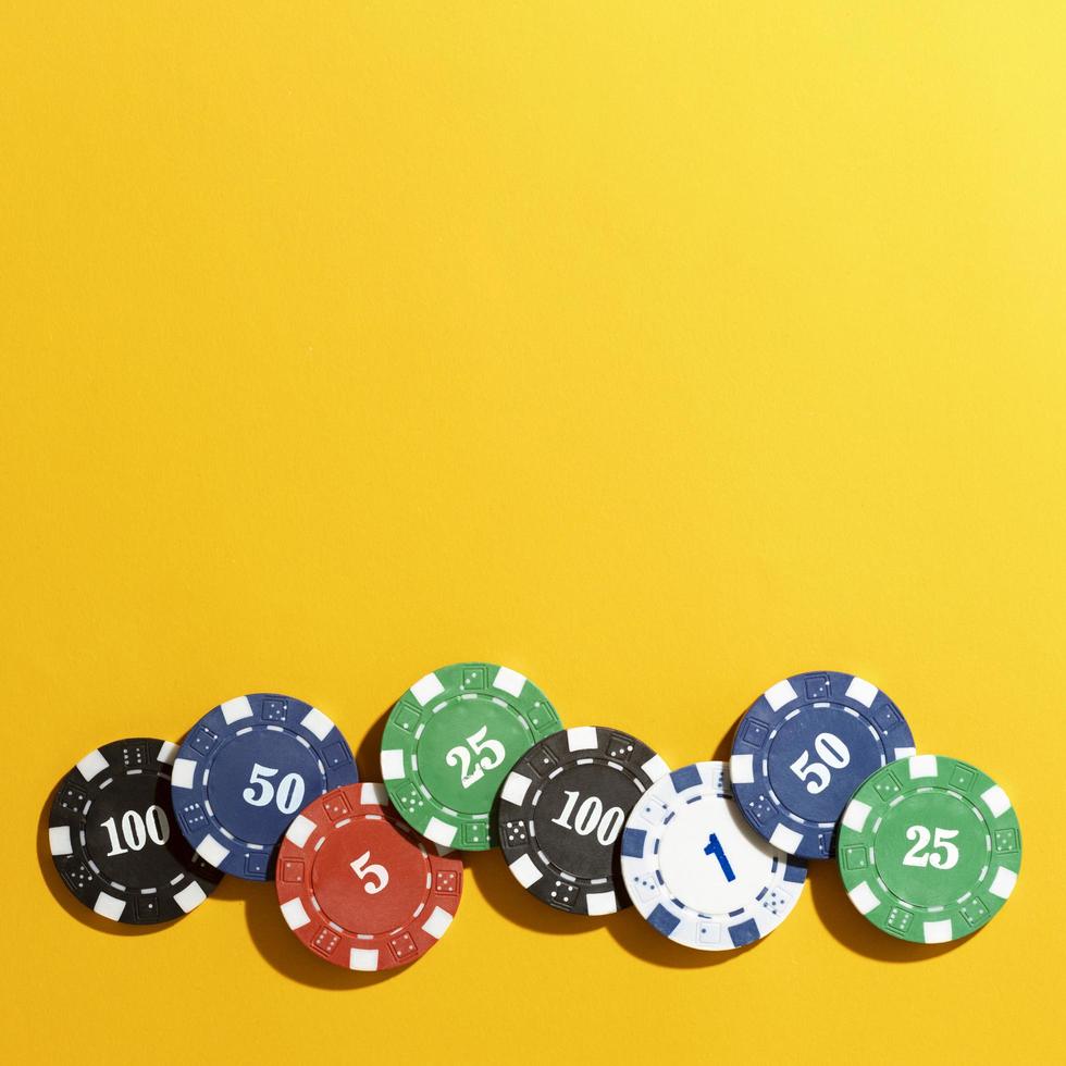 Casino tokens on yellow background photo
