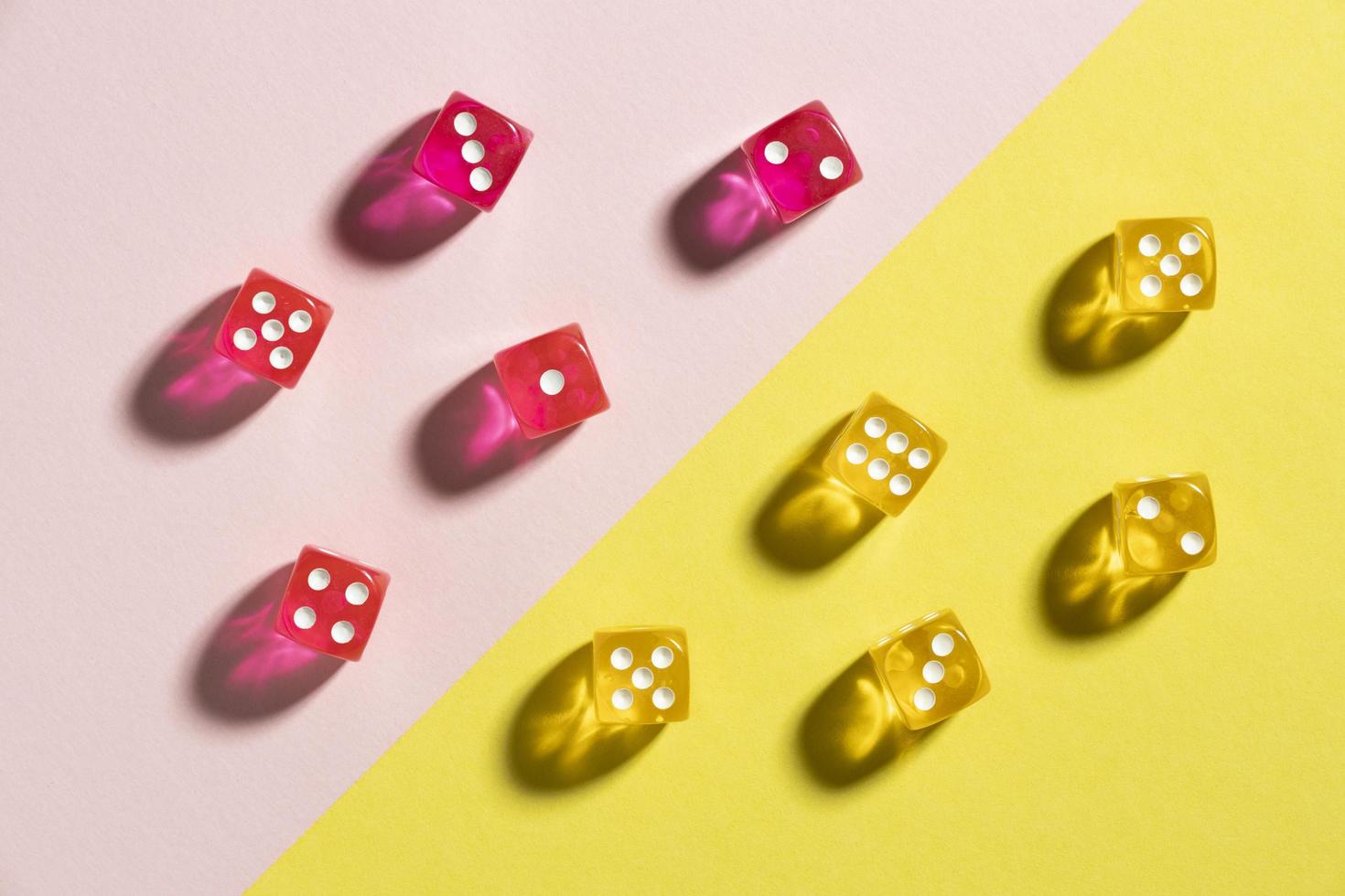 Yellow and pink dices on colorful background photo