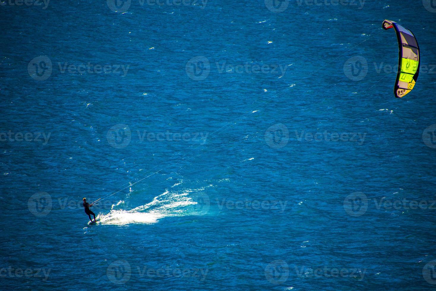 Kitesurf temprano en la mañana en el lago de Garda en Limone sul Garda, Italia foto