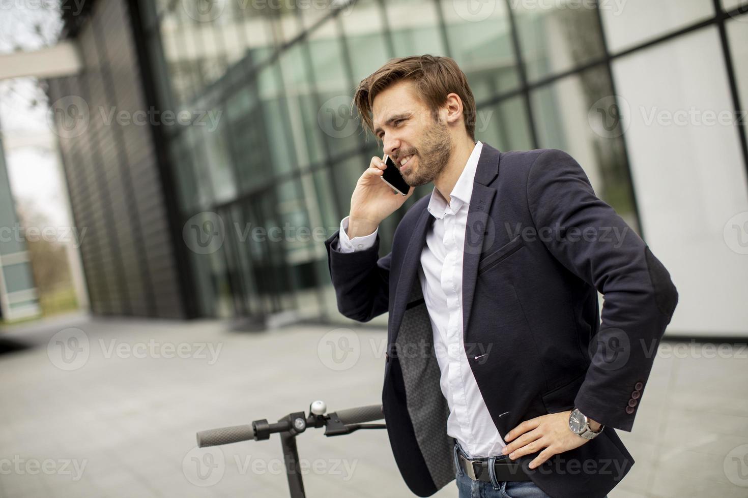 hombre tomando una llamada de negocios en un scooter foto