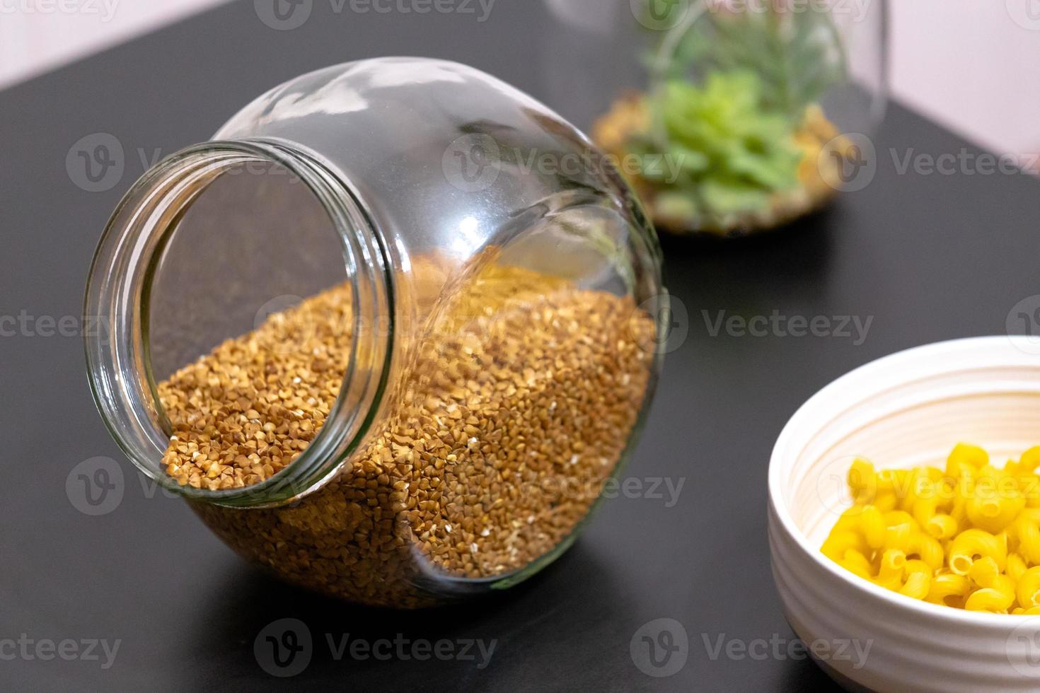 Healthy food buckwheat in a glass jar is on the table photo