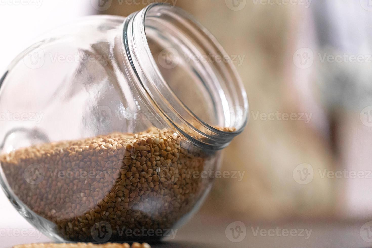 Buckwheat in a glass jar on the table photo