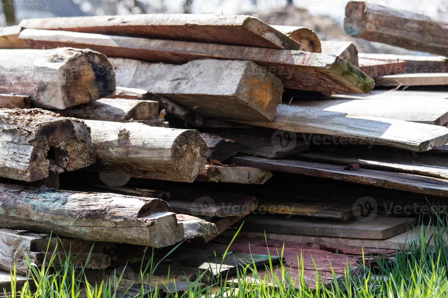 A stack of old wooden planks on the ground photo