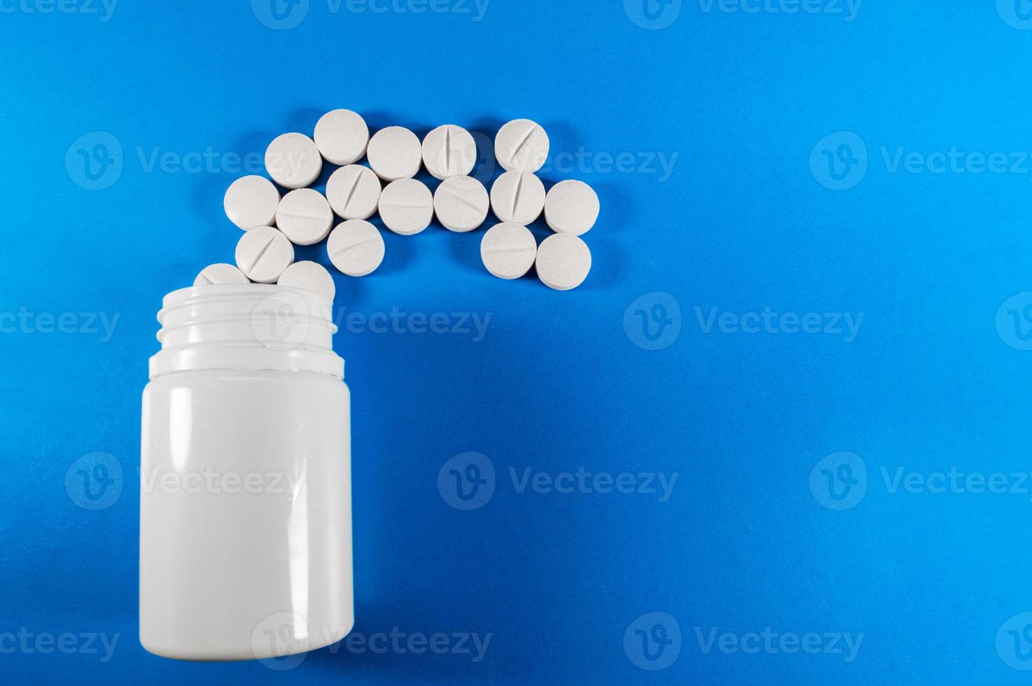 Pastillas y tabletas médicas blancas con botella foto