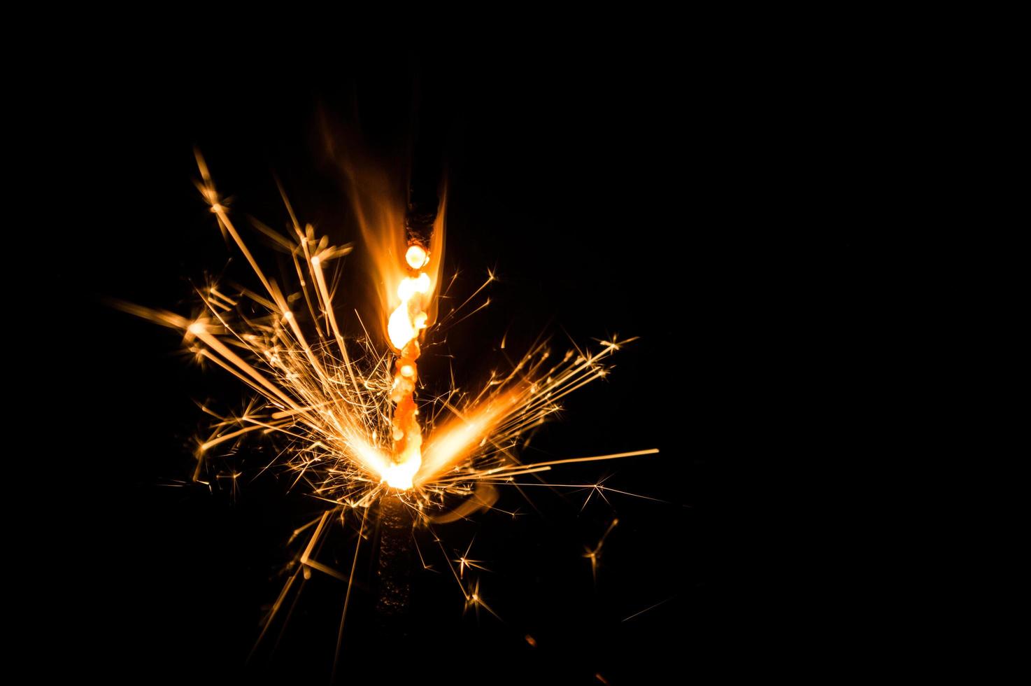 Sparkler in yellow and orange light on a black background photo