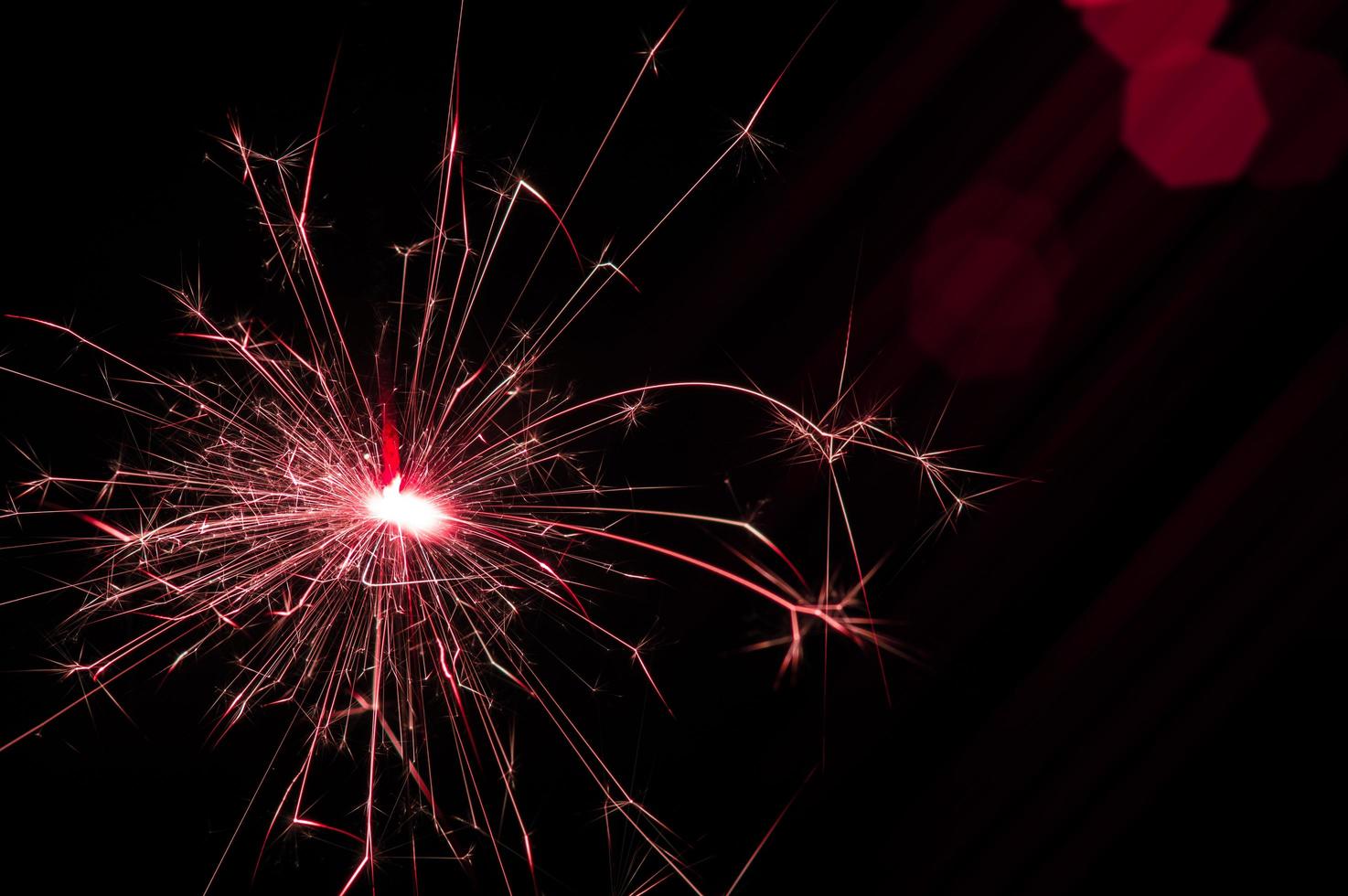 Sparkler in red and white light on a black background photo