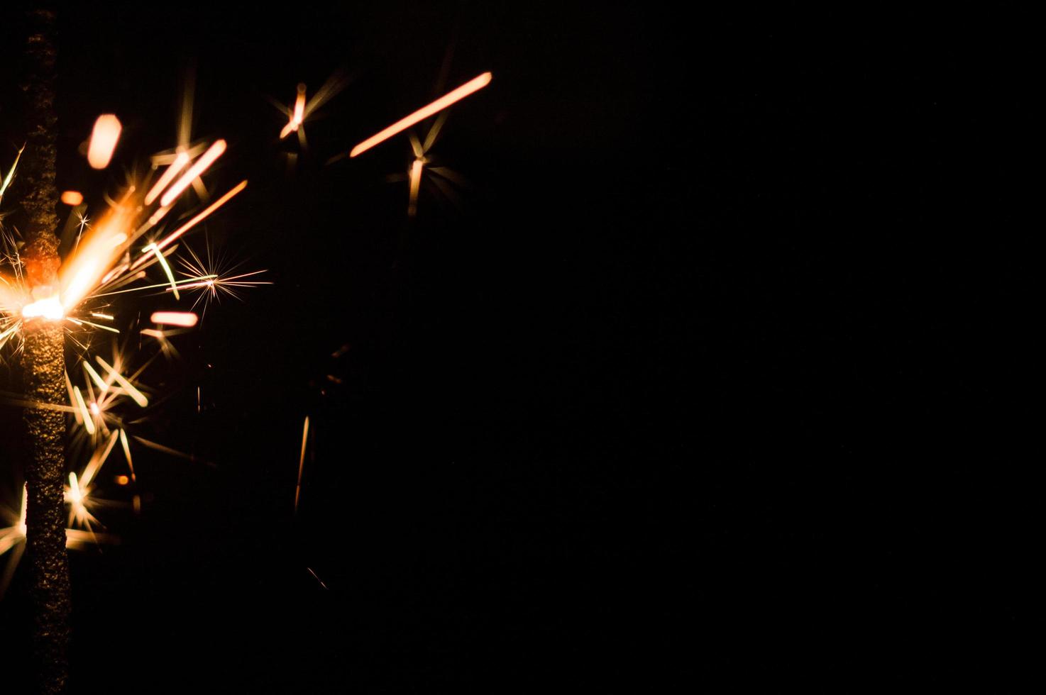 Bengala en luz amarilla y naranja sobre un fondo negro foto