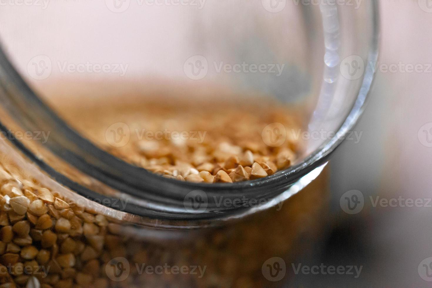 Buckwheat in a glass jar on the table photo