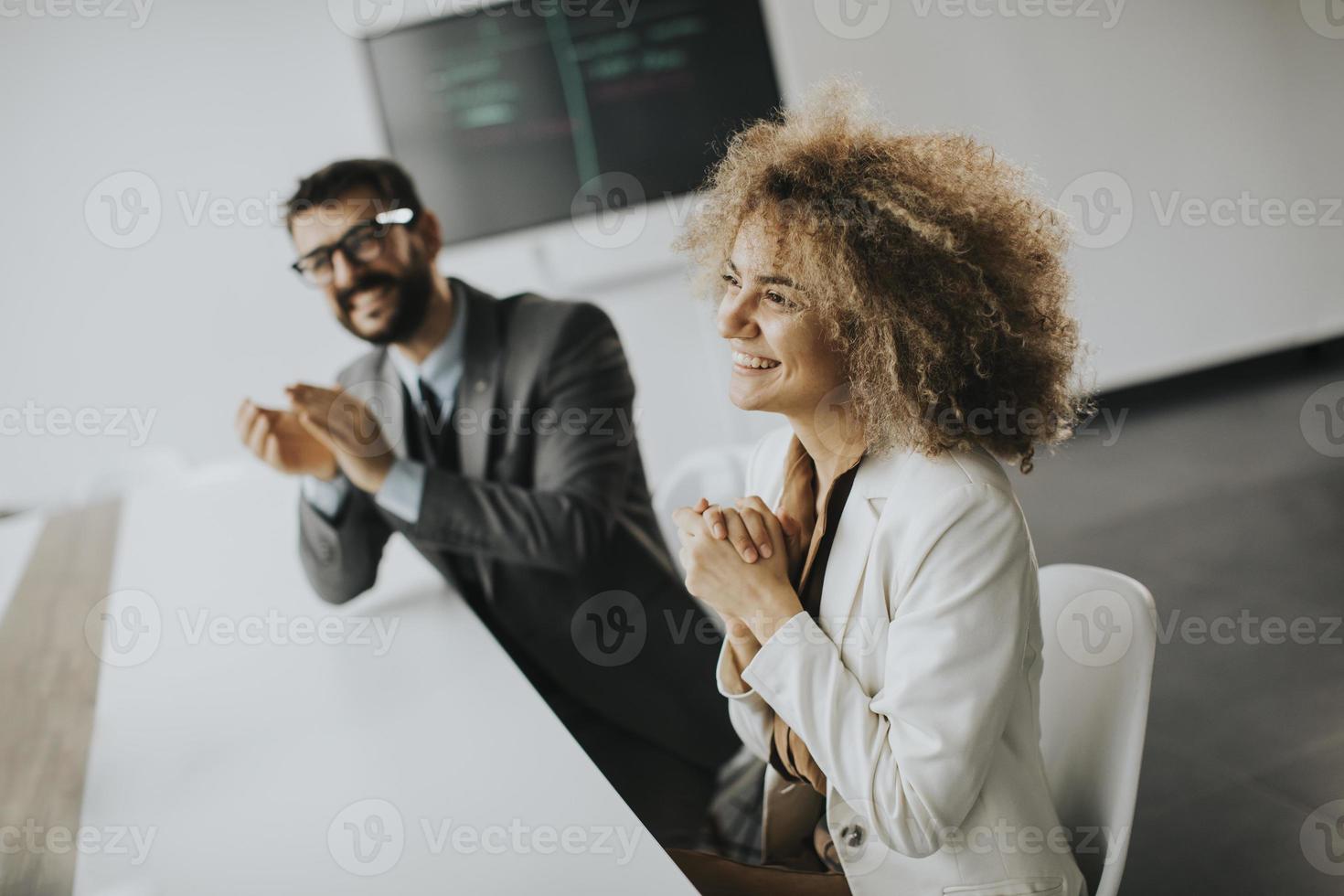 Grupo multiétnico de gente de negocios trabajando juntos y aplaudiendo después de una exitosa reunión en la oficina foto