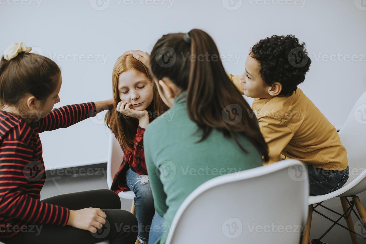 Sad little girl and supporting friends photo