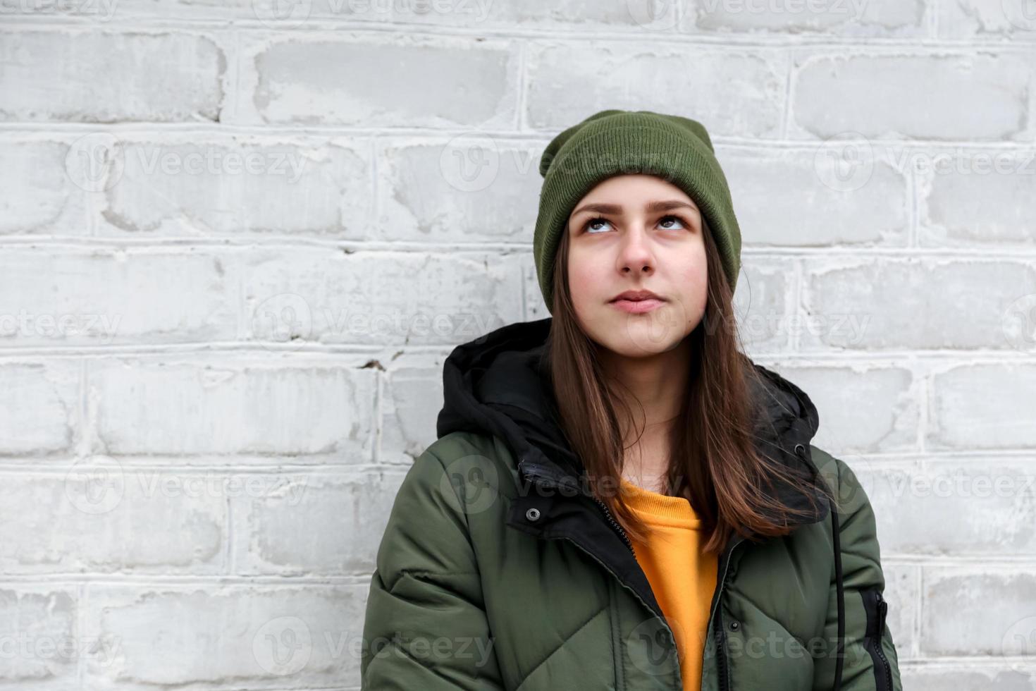 Portrait of a beautiful pensive girl in a yellow sweater and khaki hat photo