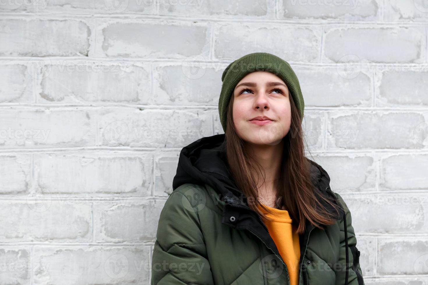 Portrait of a beautiful pensive girl in a yellow sweater and khaki hat photo