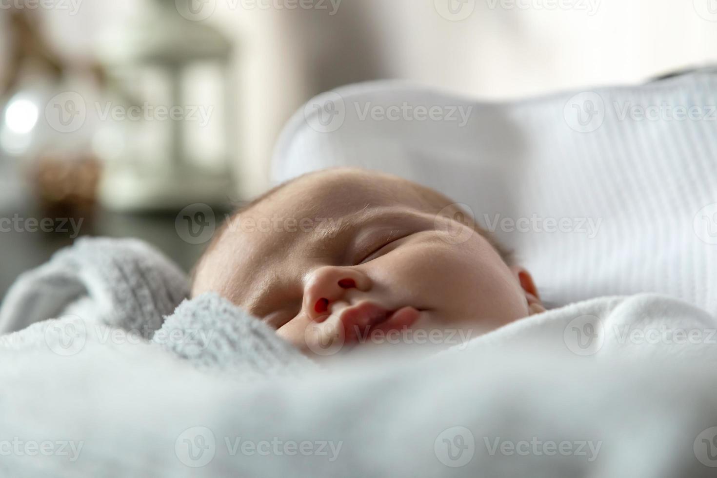 A close up portrait of a baby girl who sleeps in a cradle or crib photo