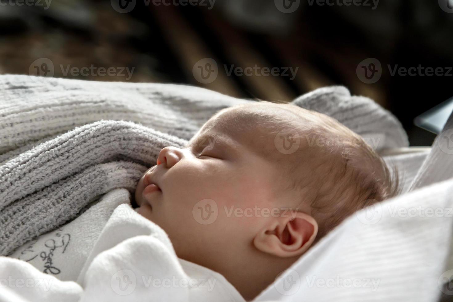 A close up portrait of a baby girl who sleeps in a cradle or crib photo
