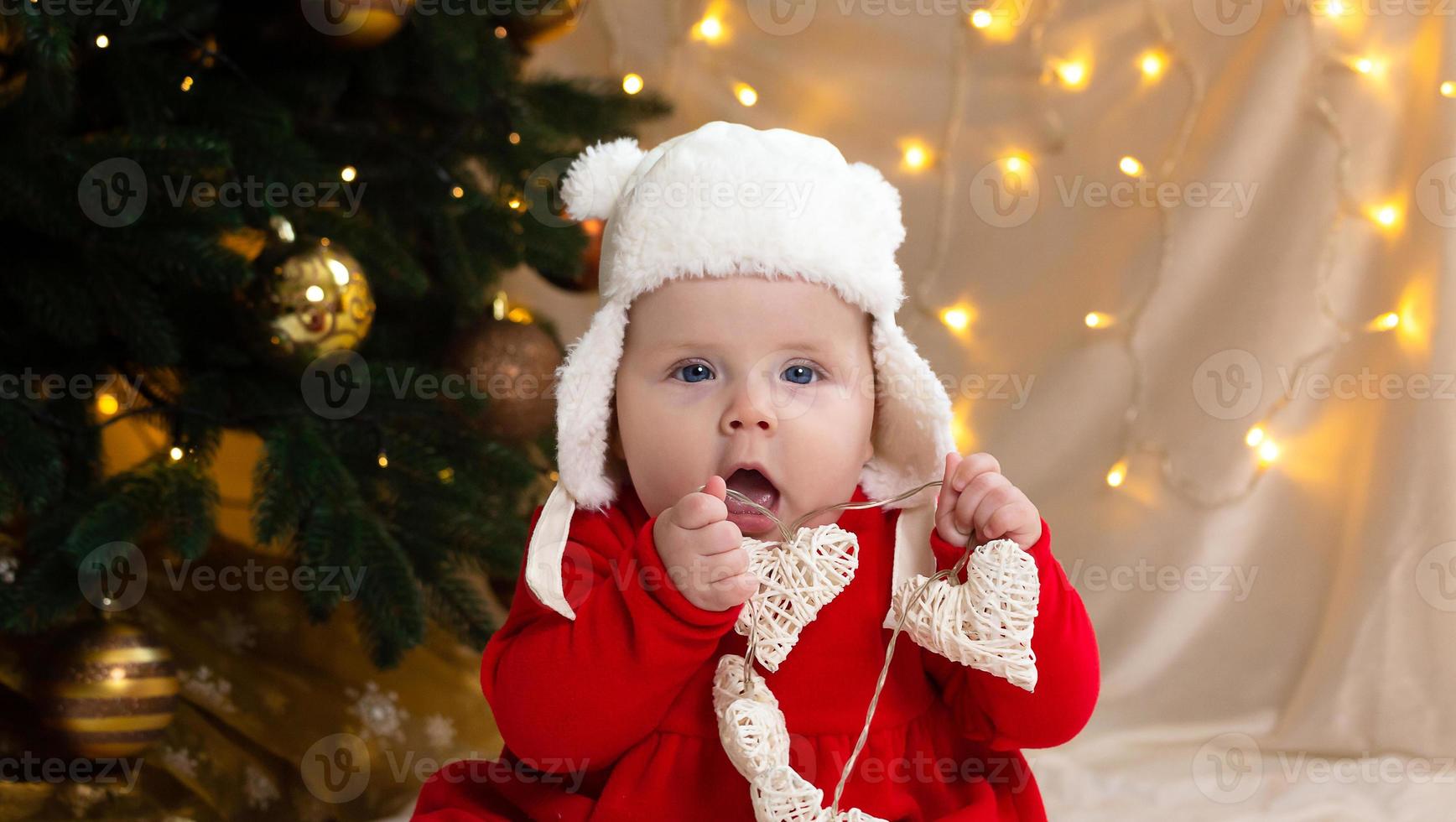 Christmas child looking at the camera and holding a garland with hearts photo