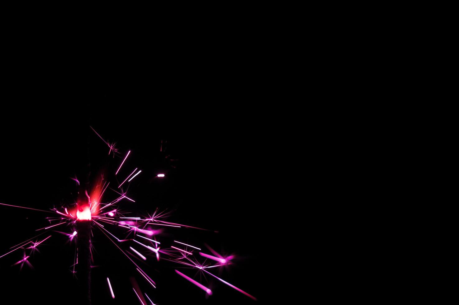 Sparkler in pink and white light on a black background photo