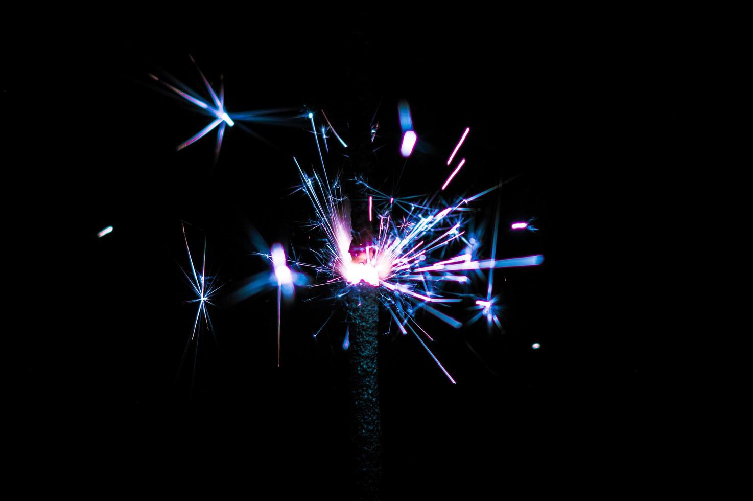 Sparkler in blue and white light on a black background photo