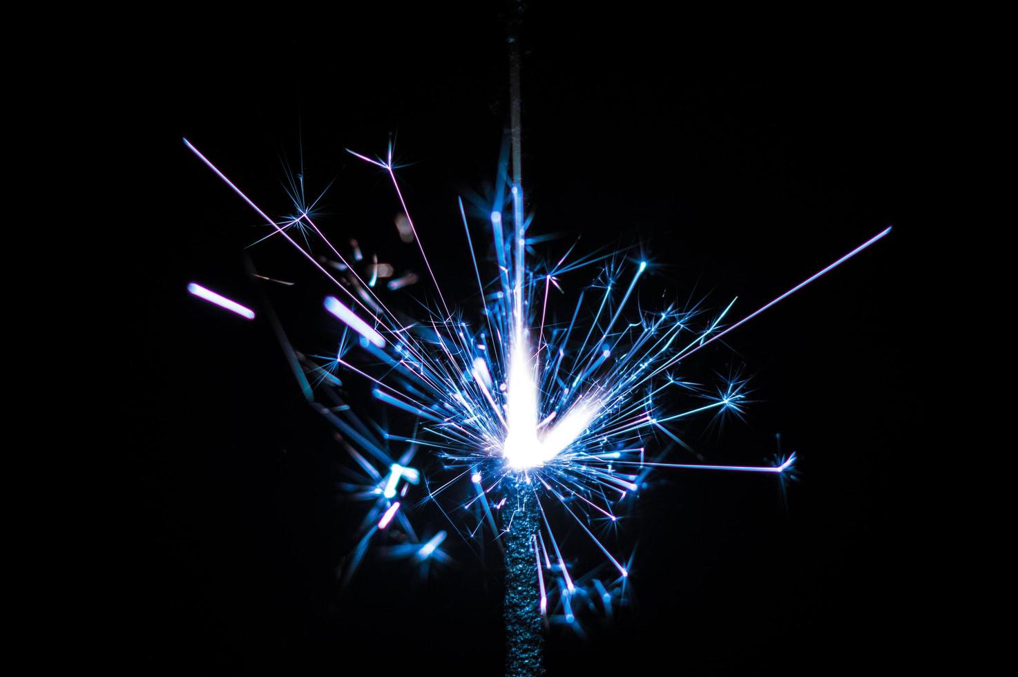 Sparkler in blue and white light on a black background photo