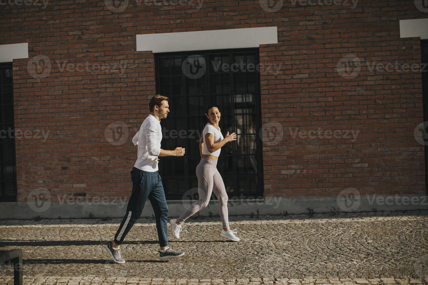 pareja joven corriendo en el entorno urbano foto